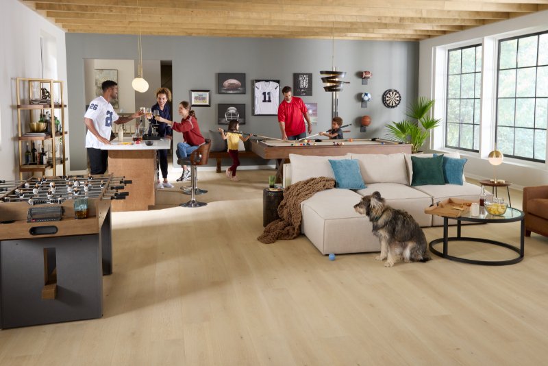 Friends playing pool in a rec room with Pergo flooring